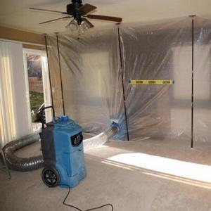 emergency water damage repair – dehumidifier and air mover placed in isolated water-damaged area