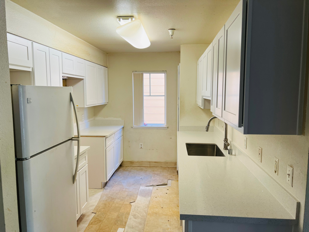 Modern kitchen remodel featuring white cabinetry, stainless steel appliances, and marble island by remodel contractor near me in San Jose.