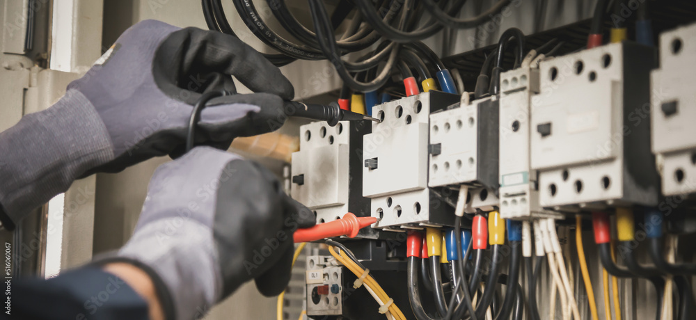 Gloved hands testing a commercial circuit breaker panel—professional electrical contractor near San Jose performing safety inspection and diagnostics.